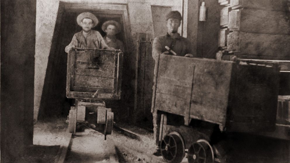 Miners pushing ore carts through the tunnels of the Gould and Curry Mine in Virginia City, Nev., in this undated photo.