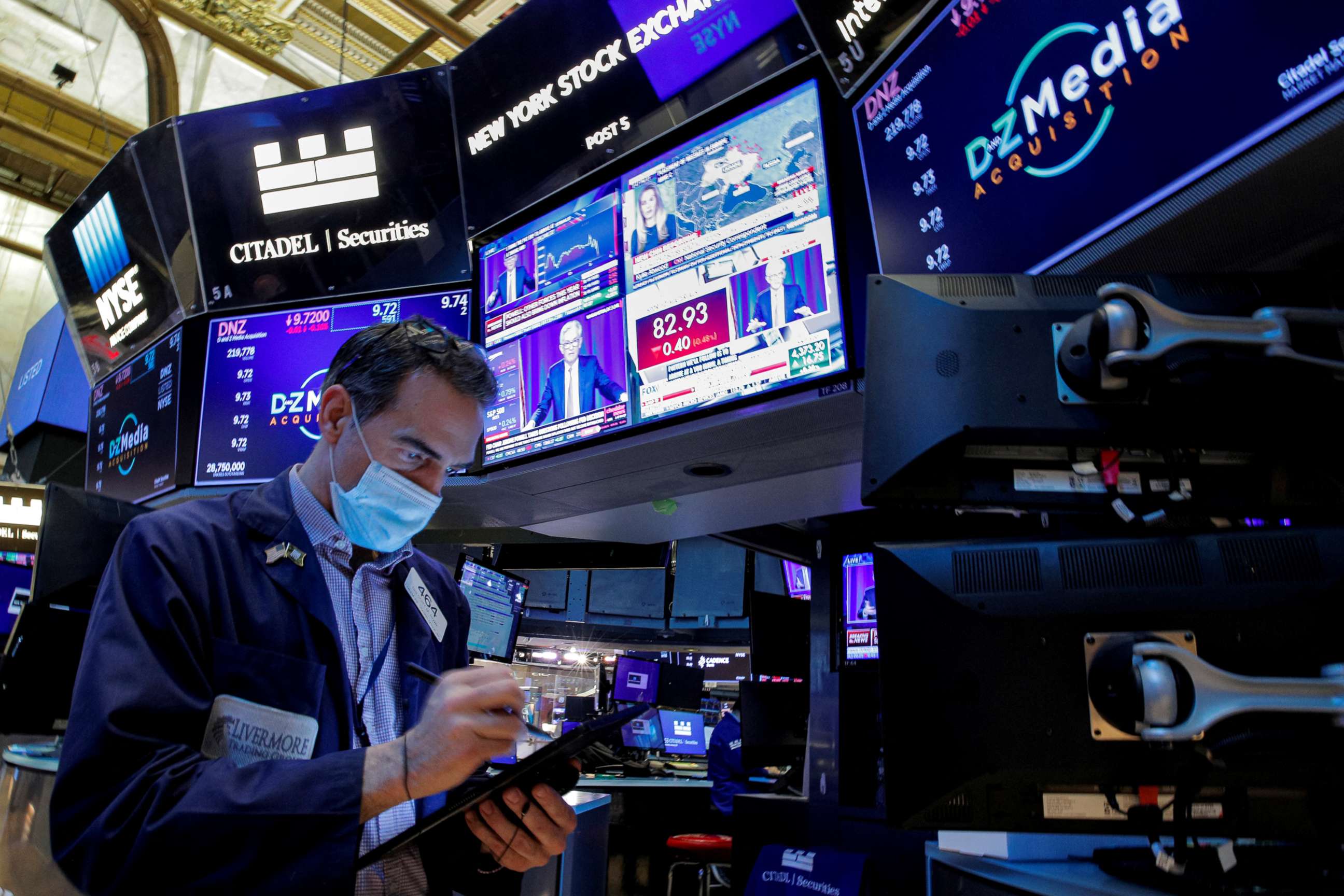 PHOTO: A trader works, as Federal Reserve Chair Jerome Powell is seen delivering remarks on screens, on the floor of the New York Stock Exchange in New York, Jan. 26, 2022.