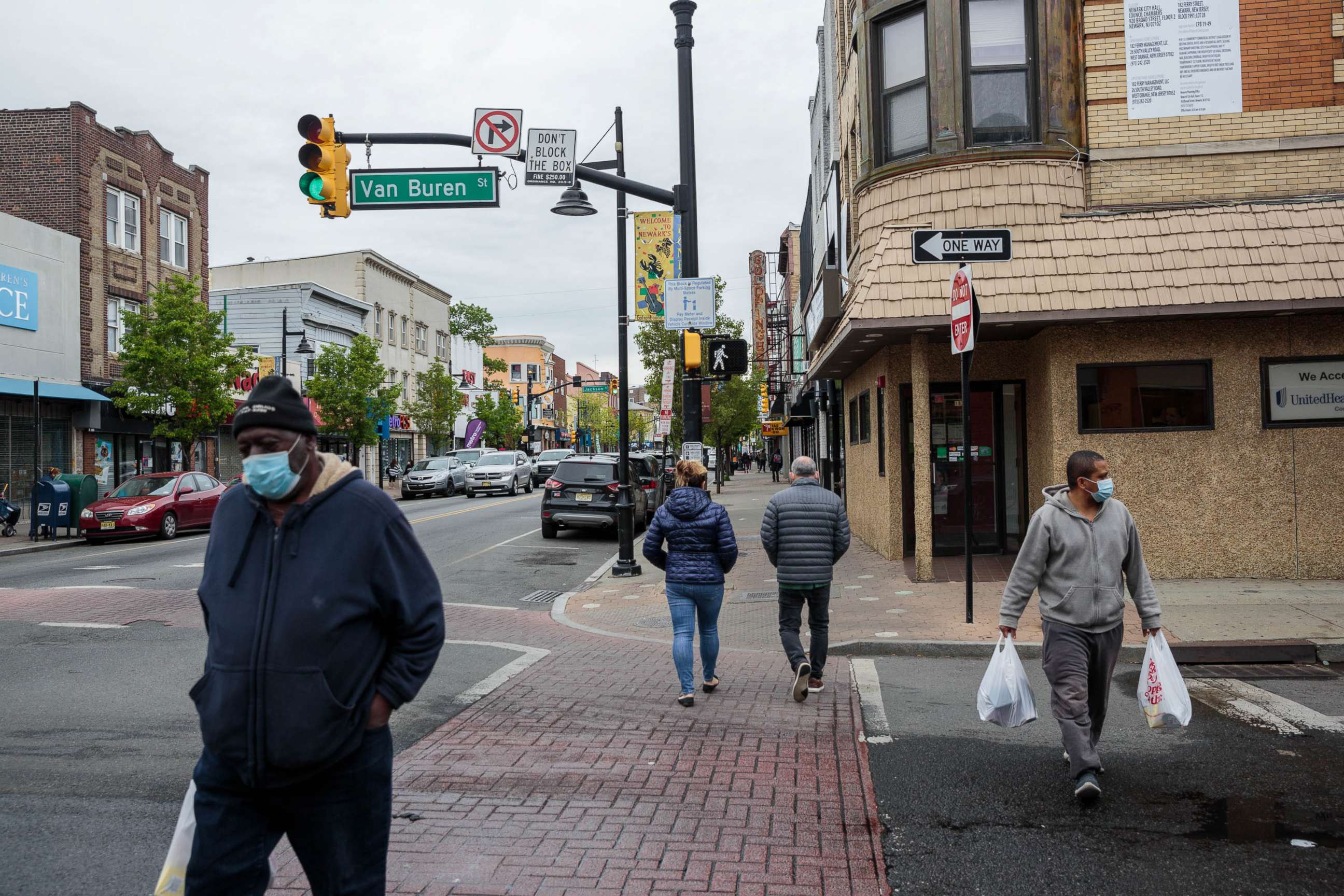PHOTO: Pedestrians wearing protective masks walk through the Ironbound district of Newark, N.J., May 6, 2020.