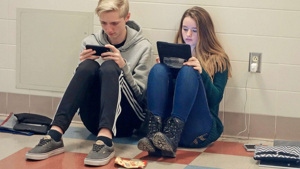 PHOTO: Teenage Boy and Girl Using iPad and Phone, Wellsville, New York, USA. (Photo by: Education Images/Universal Images Group via Getty Images)