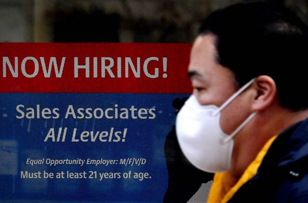 PHOTO: A man walks past a "Now Hiring" sign in front of a store on Dec. 1, 2020, in Arlington, Va.