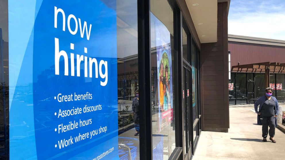 PHOTO: In this April 2, 2021, file photo, a pedestrian walks by a now hiring sign at a store in San Rafael, Calif.