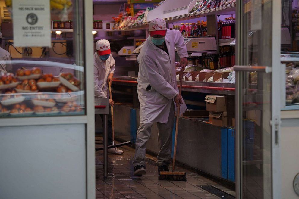 PHOTO: Workers wearing protective face masks scrub the floors at a store in Chinatown during the coronavirus pandemic on May 17, 2020 in New York City.