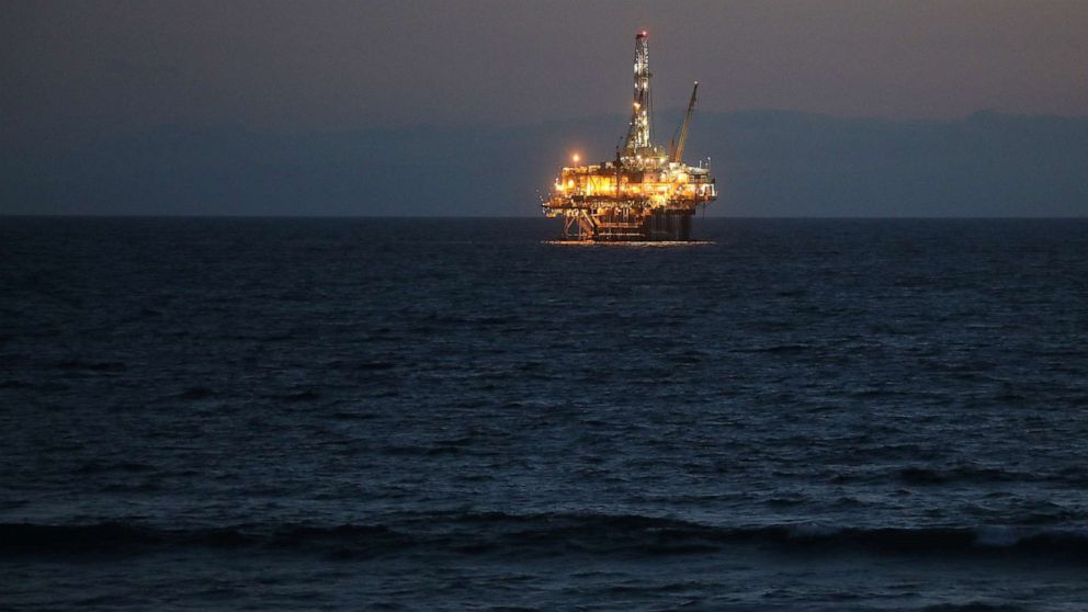 PHOTO: An offshore oil platform glows at dusk off the coast of Huntington Beach, Calif., April 20, 2020.