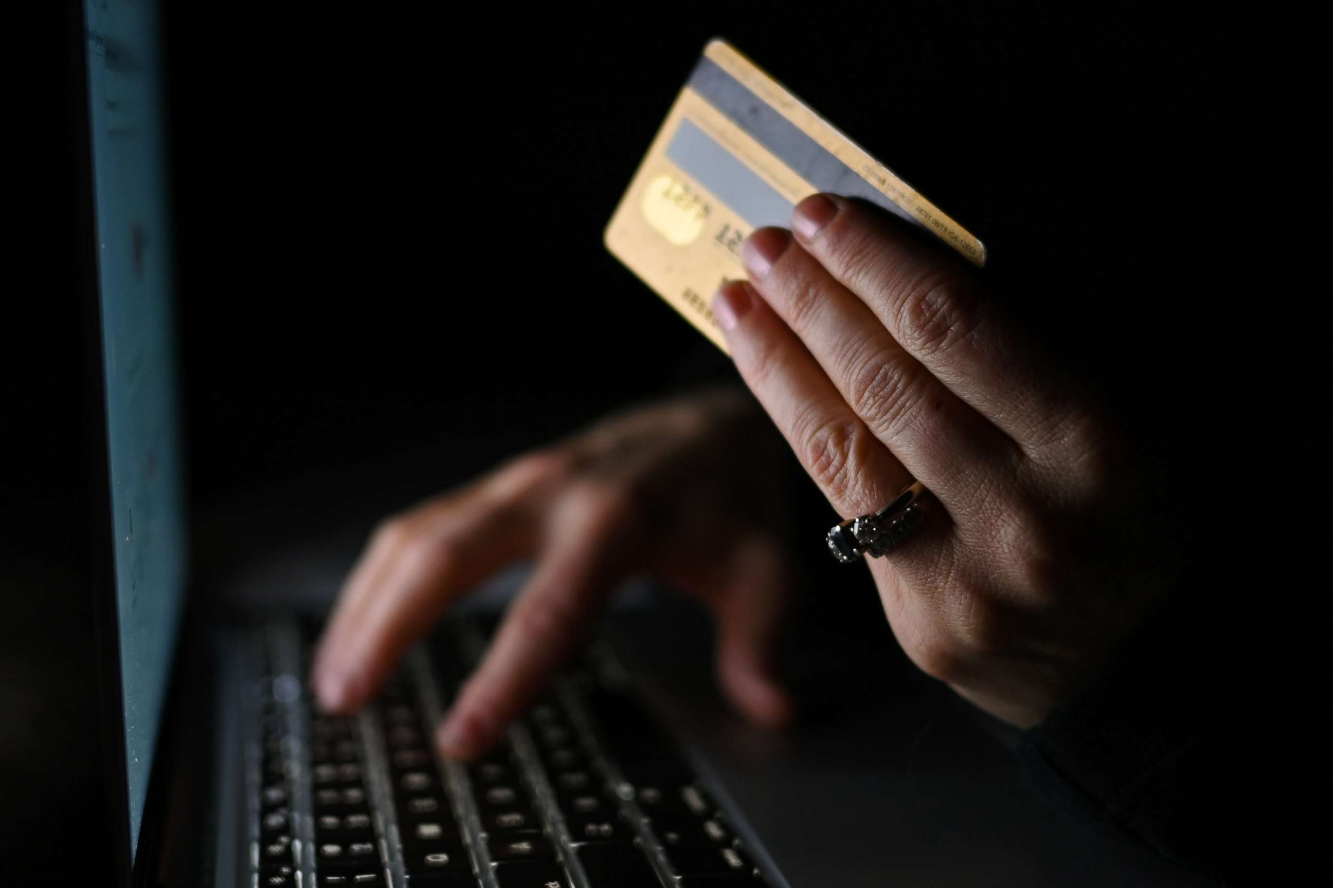 PHOTO: An illustrative image of a person holding a credit card while shopping online on a computer. 