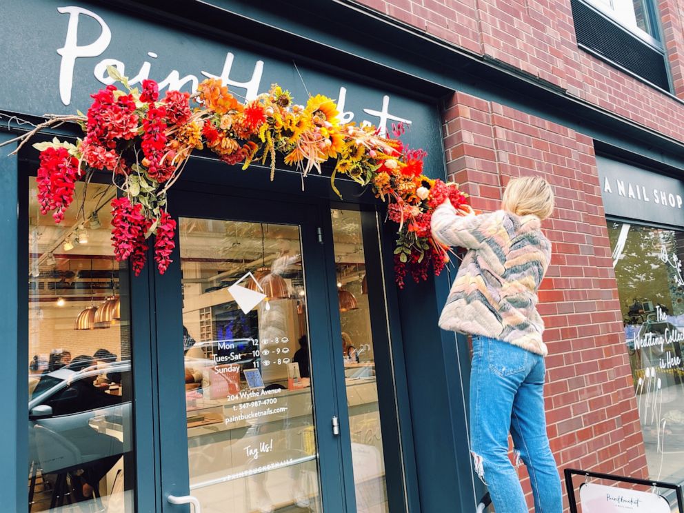 PHOTO: Paintbucket Founder Kristin Pulaski hanging flowers outside of her Brooklyn nail salon.