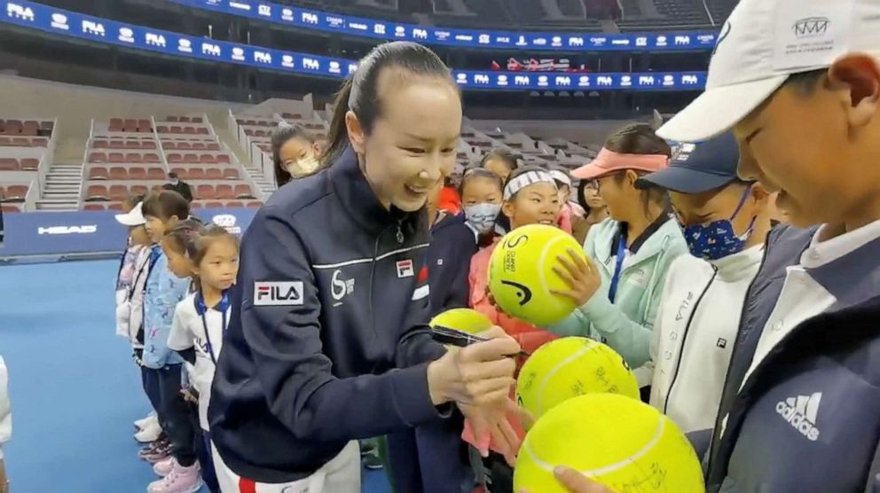 PHOTO: Tennis player Peng Shuai signs large-sized tennis balls at the opening ceremony of Fila Kids Junior Tennis Challenger Final in Beijing, Nov. 21, 2021.