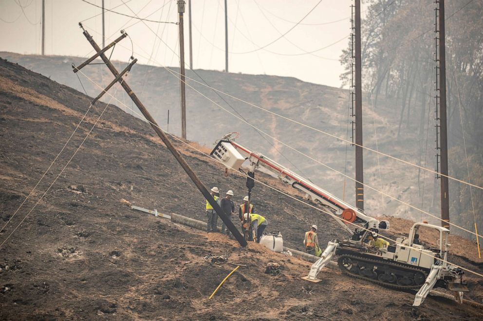 PHOTO: Utility workers with Pacific Gas & Electric Company repair a damaged power line during the Salt Fire near Lakehead, Calif. July 2, 2021.