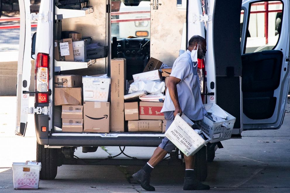 PHOTO: A mail carrier loads a truck before leaving for deliveries at a United States Postal Service (USPS) processing and distribution center in Riverdale, Maryland, Aug. 17, 2020.