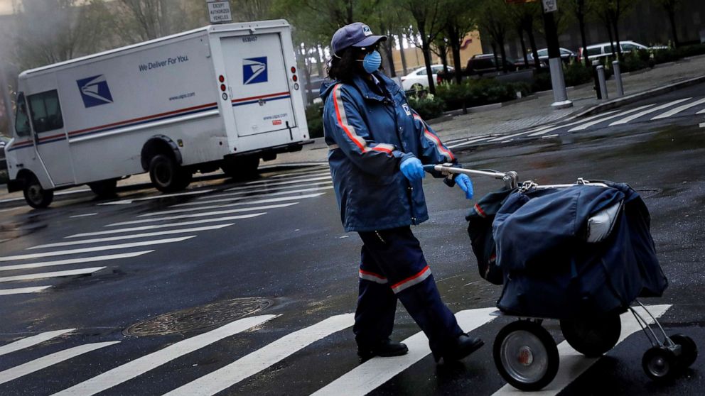 PHOTO: A United States Postal Service (USPS) worker works in the rain in Manhattan during the outbreak of the coronavirus disease (COVID-19) in New York, April 13, 2020.