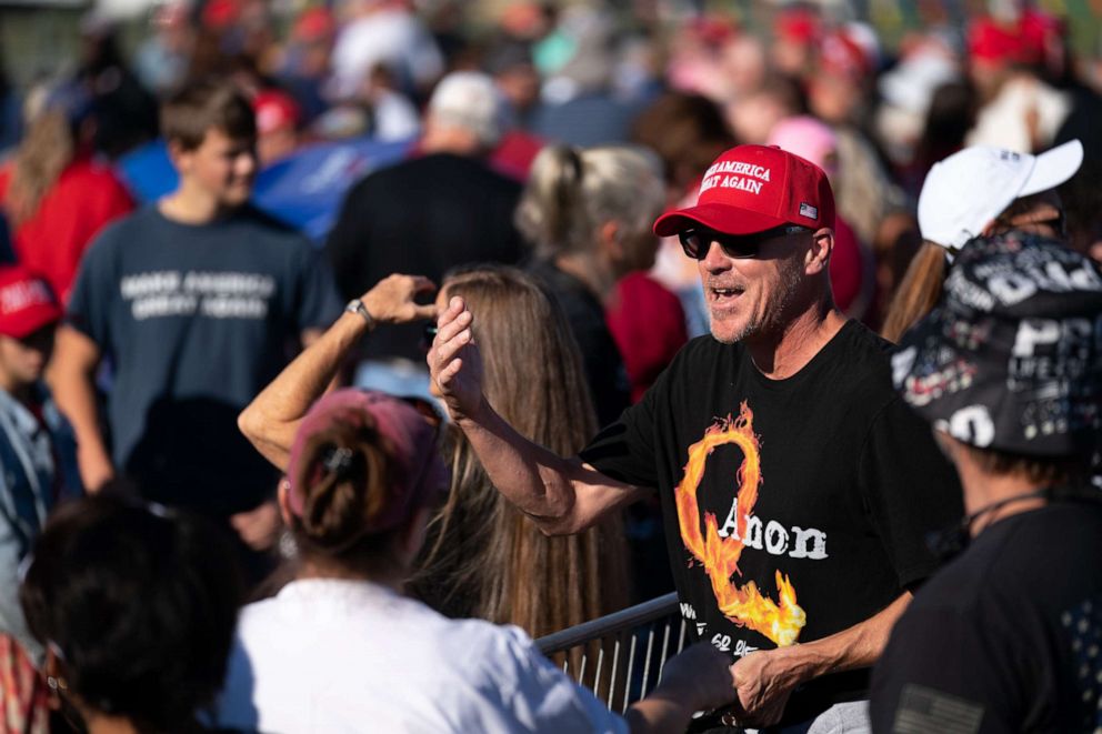 PHOTO: A man wearing a QAnon t-shirt waits in line for a rally featuring former President Donald Trump on September 25, 2021 in Perry, Georgia. 