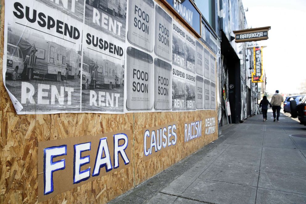 PHOTO: Signs that read "suspend rent" and "fear causes racism" are pictured on a boarded-up business in Seattle's Capitol Hill neighborhood as efforts continue to help slow the spread of coronavirus disease (COVID-19) in Seattle, March 29, 2020.