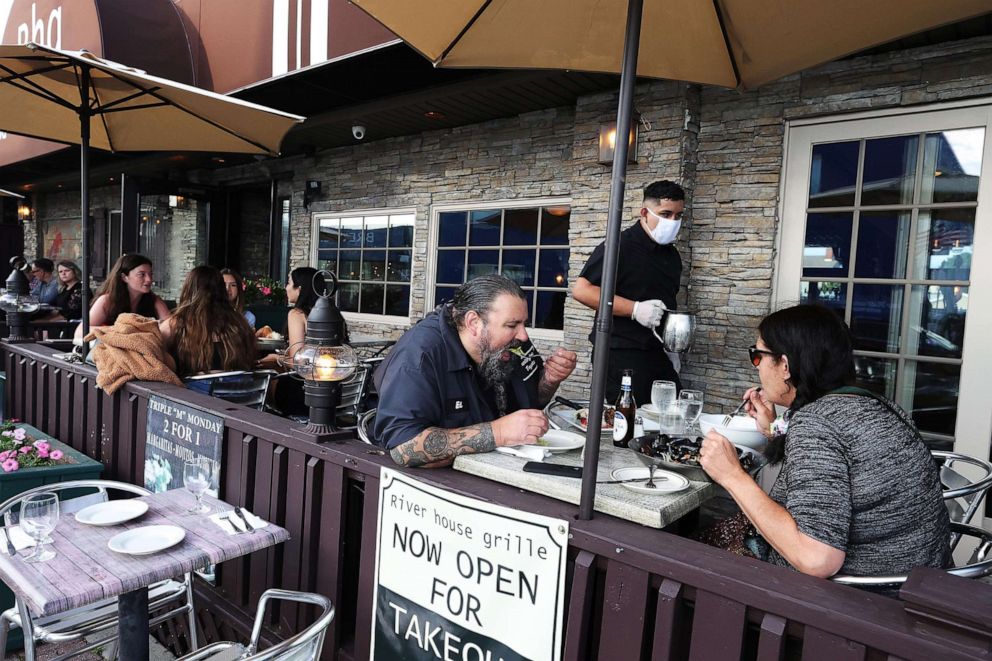 PHOTO: People eat dinner at the River House Grille on the Nautical Mile on June 10, 2020 in Freeport, N.Y.  