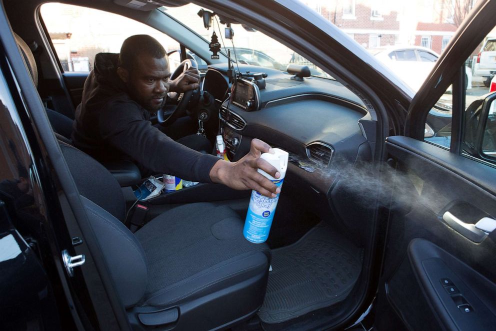 PHOTO: Uber and Lyft driver Adama Fofana sprays disinfectant in his car in New York City, March 9, 2020.