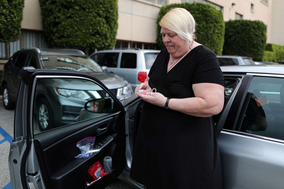 PHOTO: Uber and Lyft driver Tammie Jean Lane, 60, holds a bottle of hand sanitizer during the global outbreak of coronavirus (COVID-19) in Los Angeles, March 16, 2020.