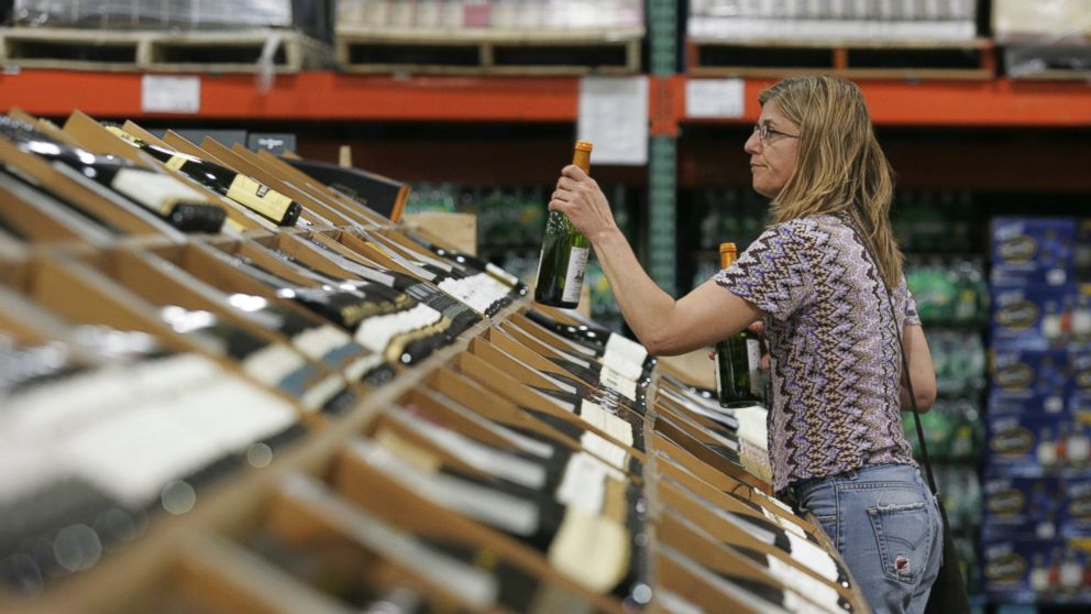 A shopper selects bottles of wine at the Costco Warehouse in Arlington, Va.on May 29, 2008.