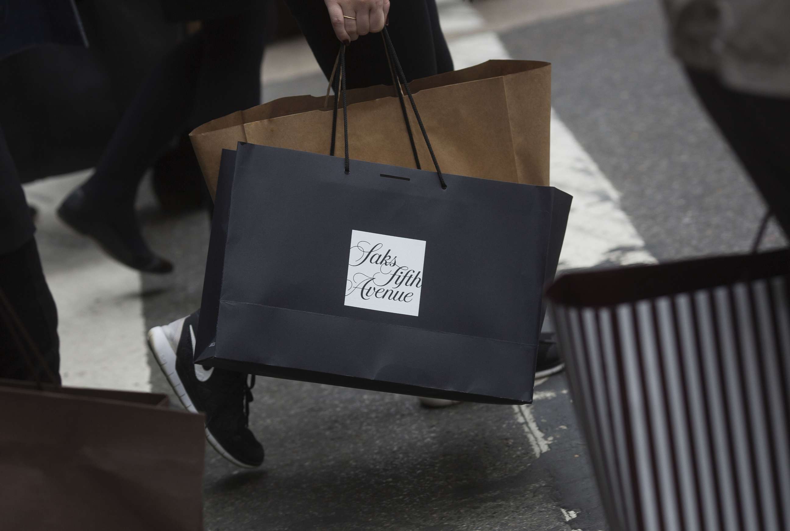PHOTO: A customer carries a Saks Fifth Avenue shopping bag while walking on Fifth Avenue in New York, March 24, 2016.
