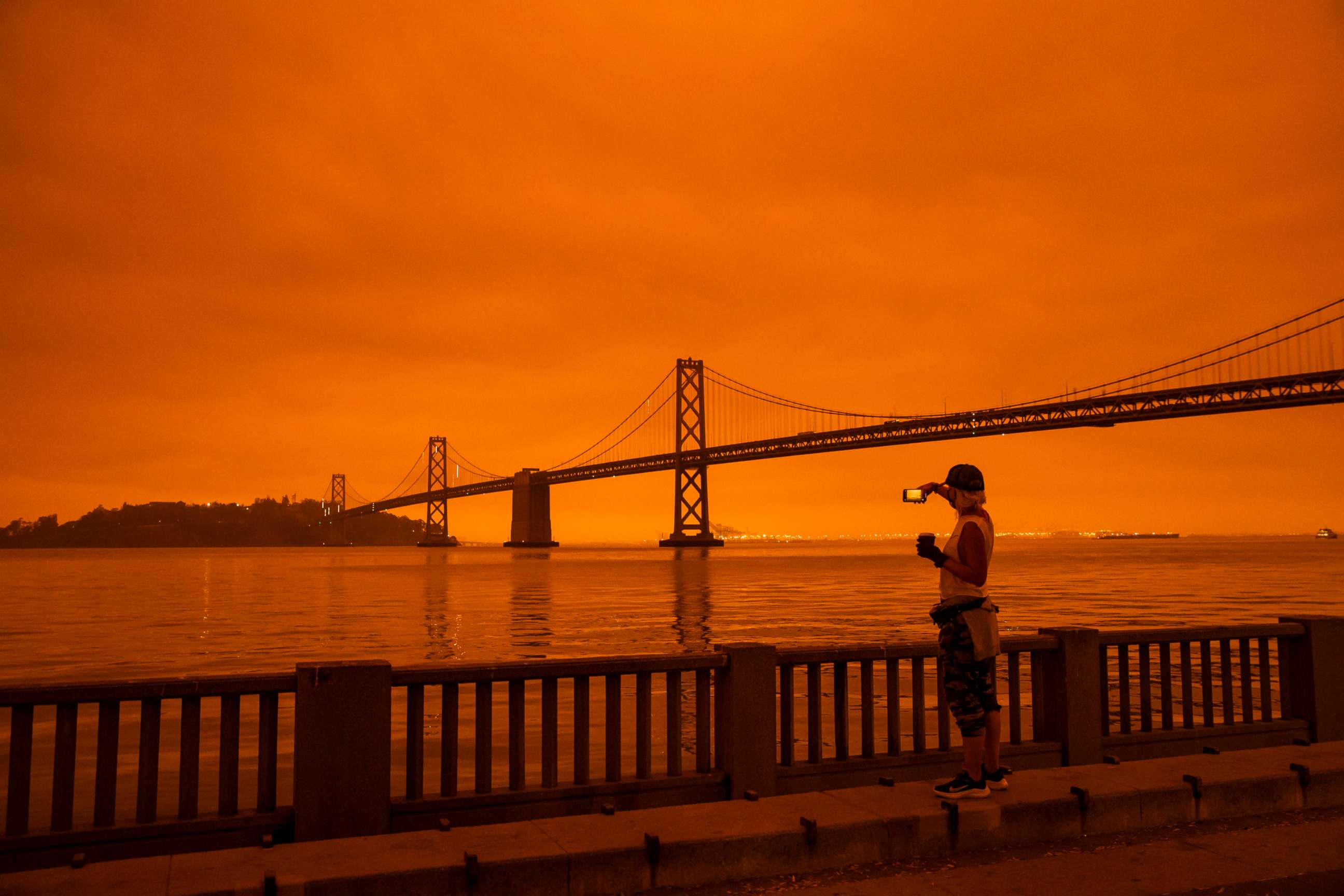 PHOTO: In this Sept. 9, 2020, file photo, a person takes in the view from the Embarcadero as smoke from various wildfires burning across Northern California mixes with the marine layer, blanketing San Francisco in darkness and an orange glow.