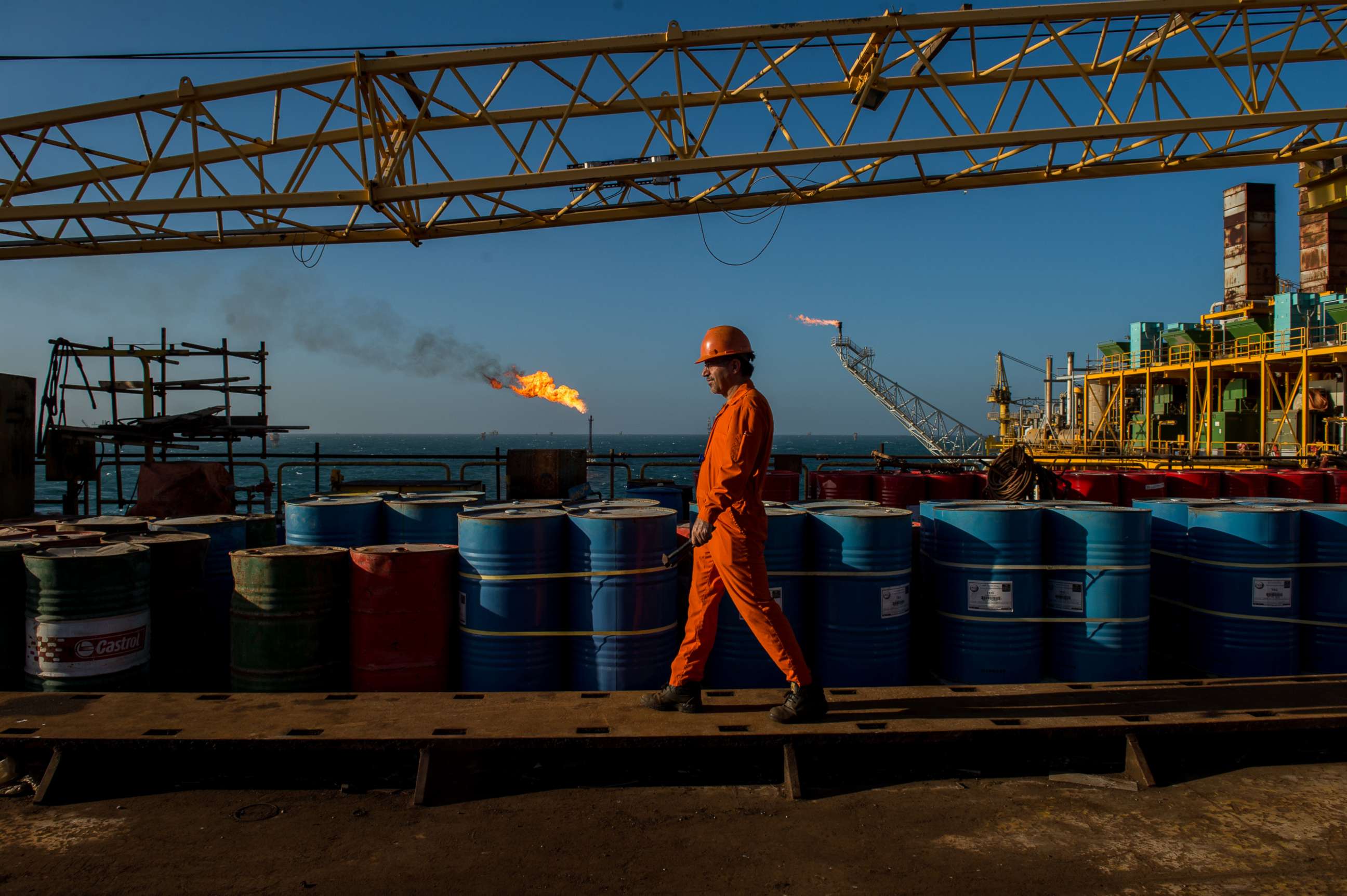 PHOTO: A worker passes stores of oil drums and gas flares while working aboard an offshore oil platform in the Persian Gulf's Salman Oil Field, near Lavan island, Iran, in this Jan. 6. 2017 file photo.