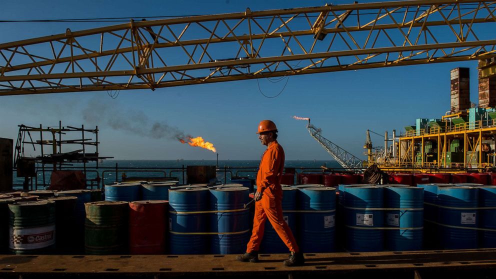 PHOTO: A worker passes stores of oil drums and gas flares while working aboard an offshore oil platform in the Persian Gulf's Salman Oil Field, near Lavan island, Iran, in this Jan. 6. 2017 file photo.