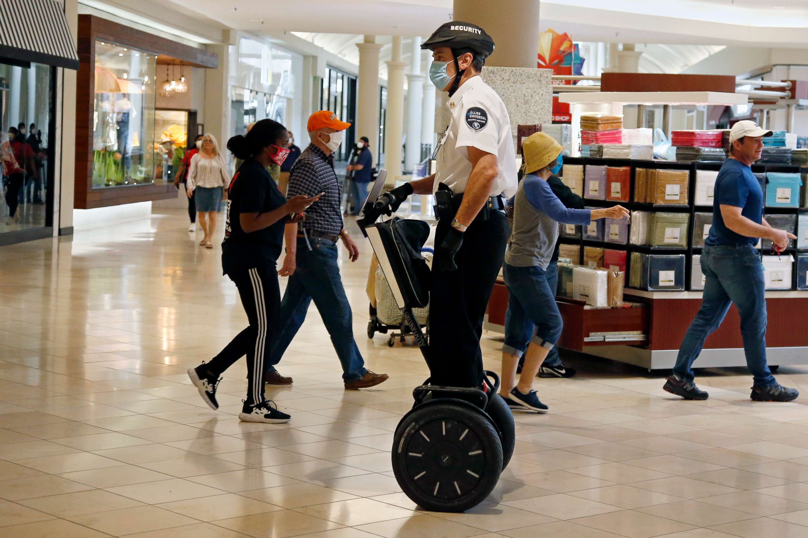 PHOTO: In this May 1, 2020 file photo, a security guard wearing a mask and riding a Segway patrols inside Penn Square Mall as the mall reopens in Oklahoma City.