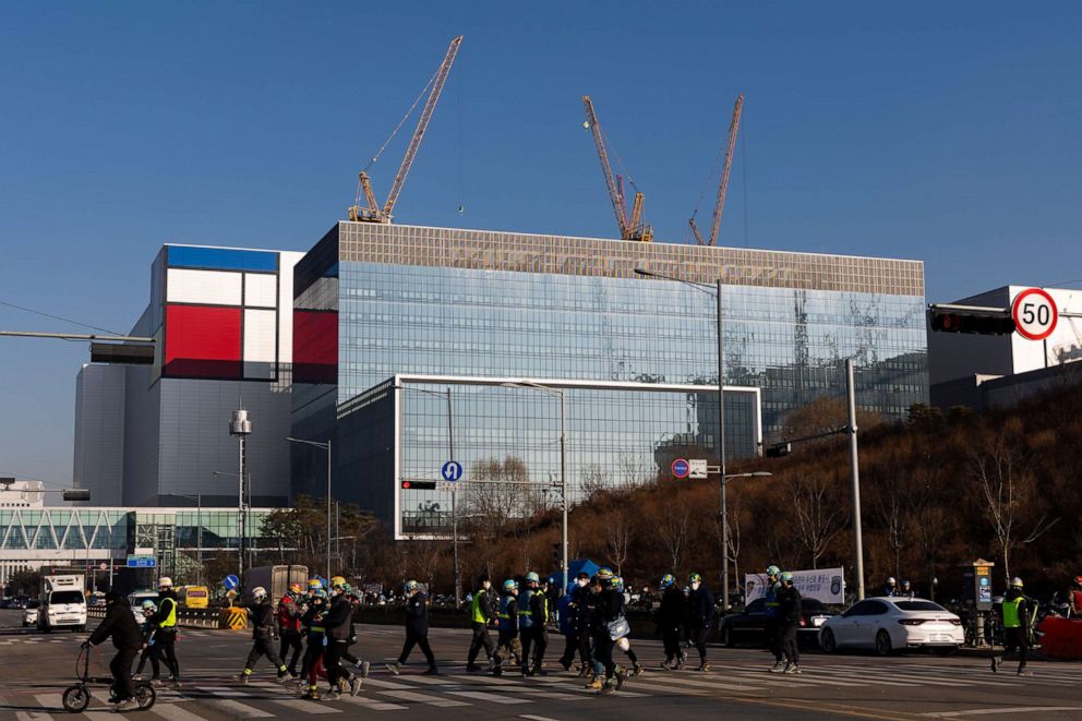 PHOTO: Workers cross a road in front of the Samsung Electronics Co. semiconductor manufacturing plant in Pyeongtaek, South Korea on Jan. 6, 2022.