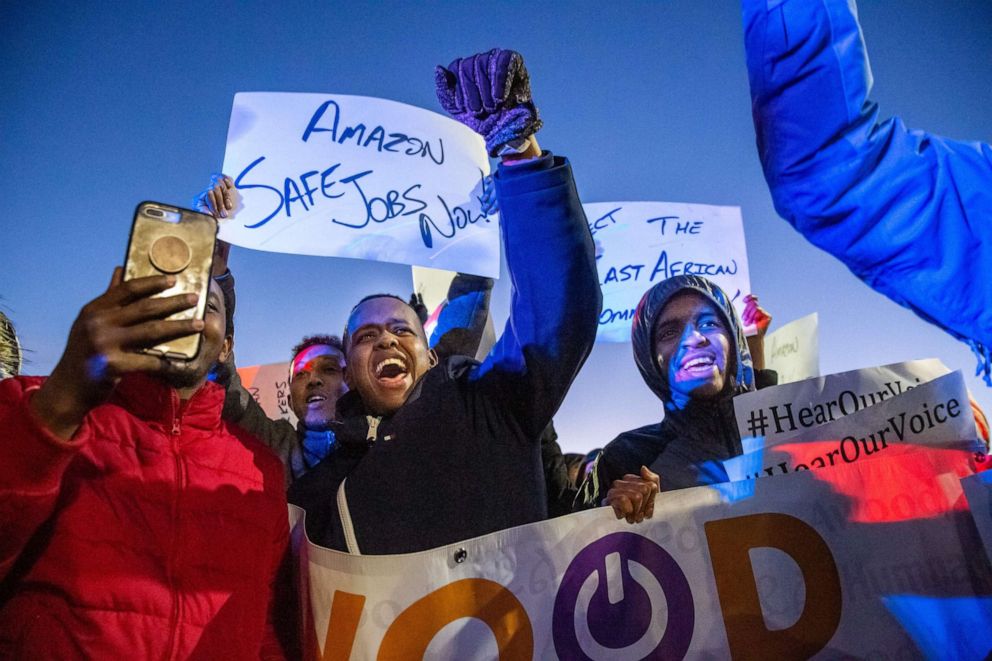 PHOTO: Demonstrators shout slogans and hold placards during a protest at the Amazon fulfillment center in Shakopee, Minn., Dec. 14, 2018.