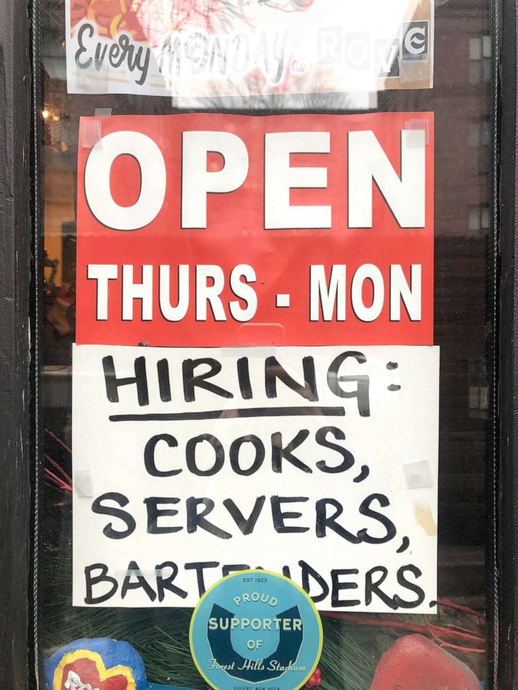 PHOTO: A sign displayed on a restaurant door advertises job openings for cooks, servers and bartenders in Queens, New York, Dec. 29, 2021. 