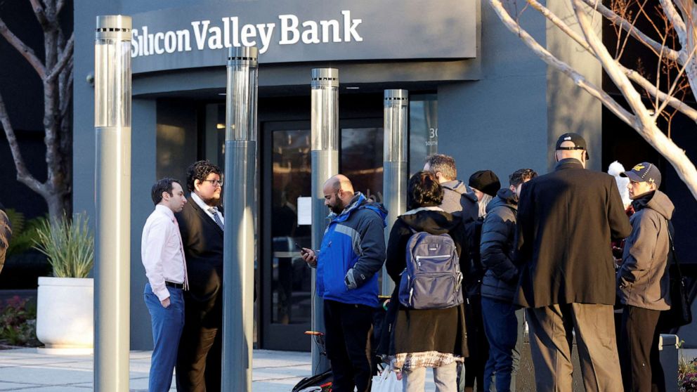 PHOTO: FDIC representatives speak with customers outside of the Silicon Valley Bank headquarters in Santa Clara, Calif., on March 13, 2023.