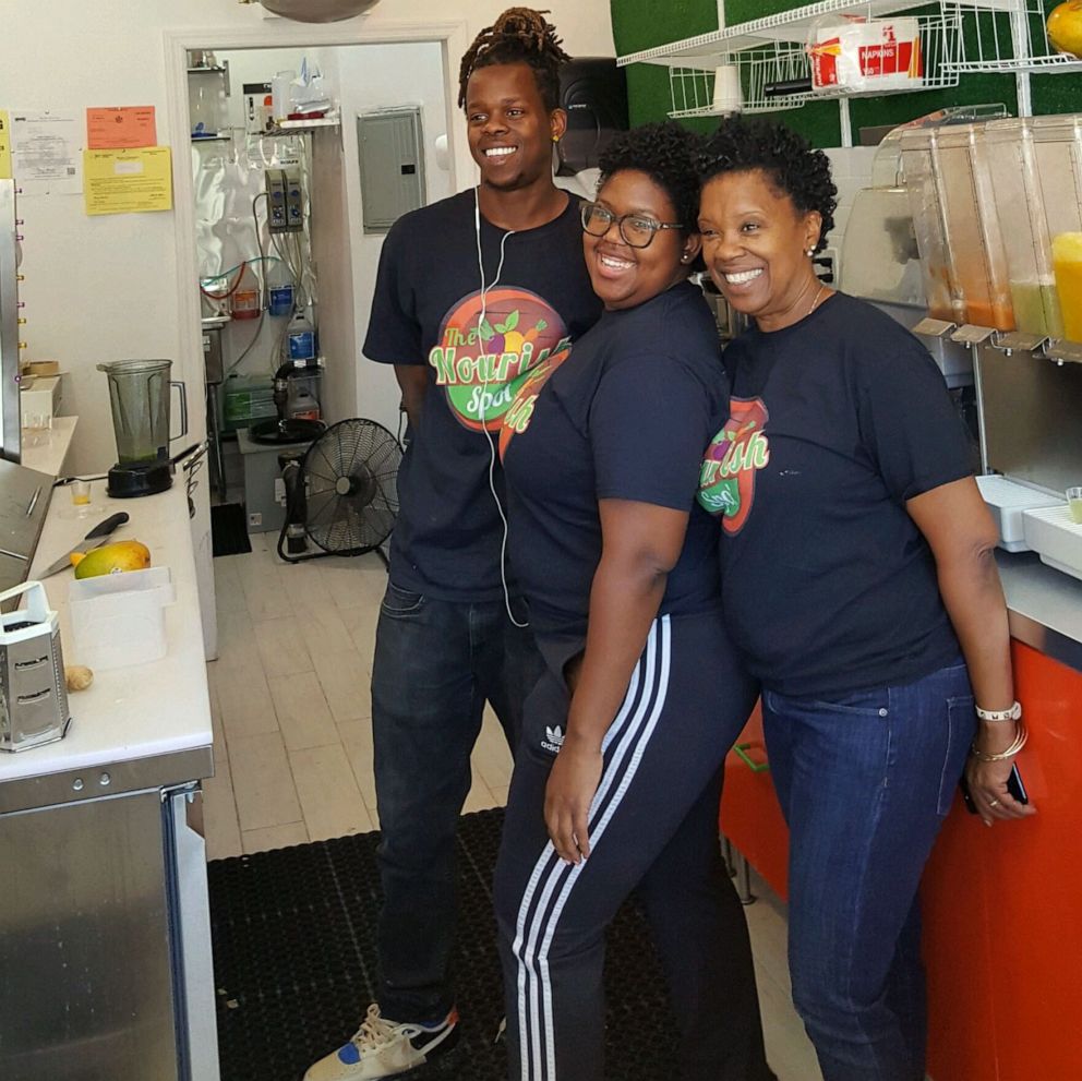 PHOTO: Dawn Kelly, a small business owner in New York City, poses for a photo at work with her two children.