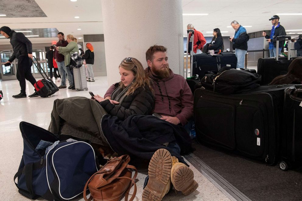 PHOTO: Kelli Jones leans against Florida's James Heyburn as they wait for a rental car to be ready after their flight with Southwest Airlines was canceled at Nashville International Airport in Nashville, Tennessee on December 27 2022.