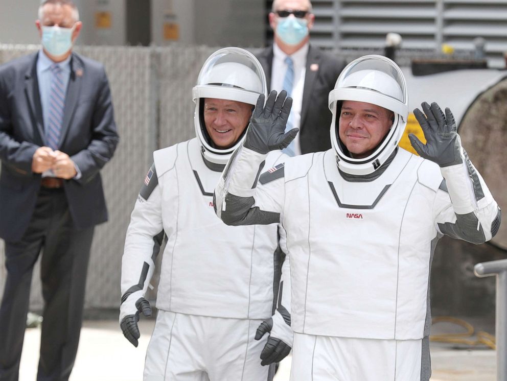 PHOTO: NASA astronauts Bob Behnken (R) and Doug Hurley (L) walk out on their way to the SpaceX Falcon 9 rocket with the Crew Dragon spacecraft at the Kennedy Space Center in Cape Canaveral, Fla., May 27, 2020.