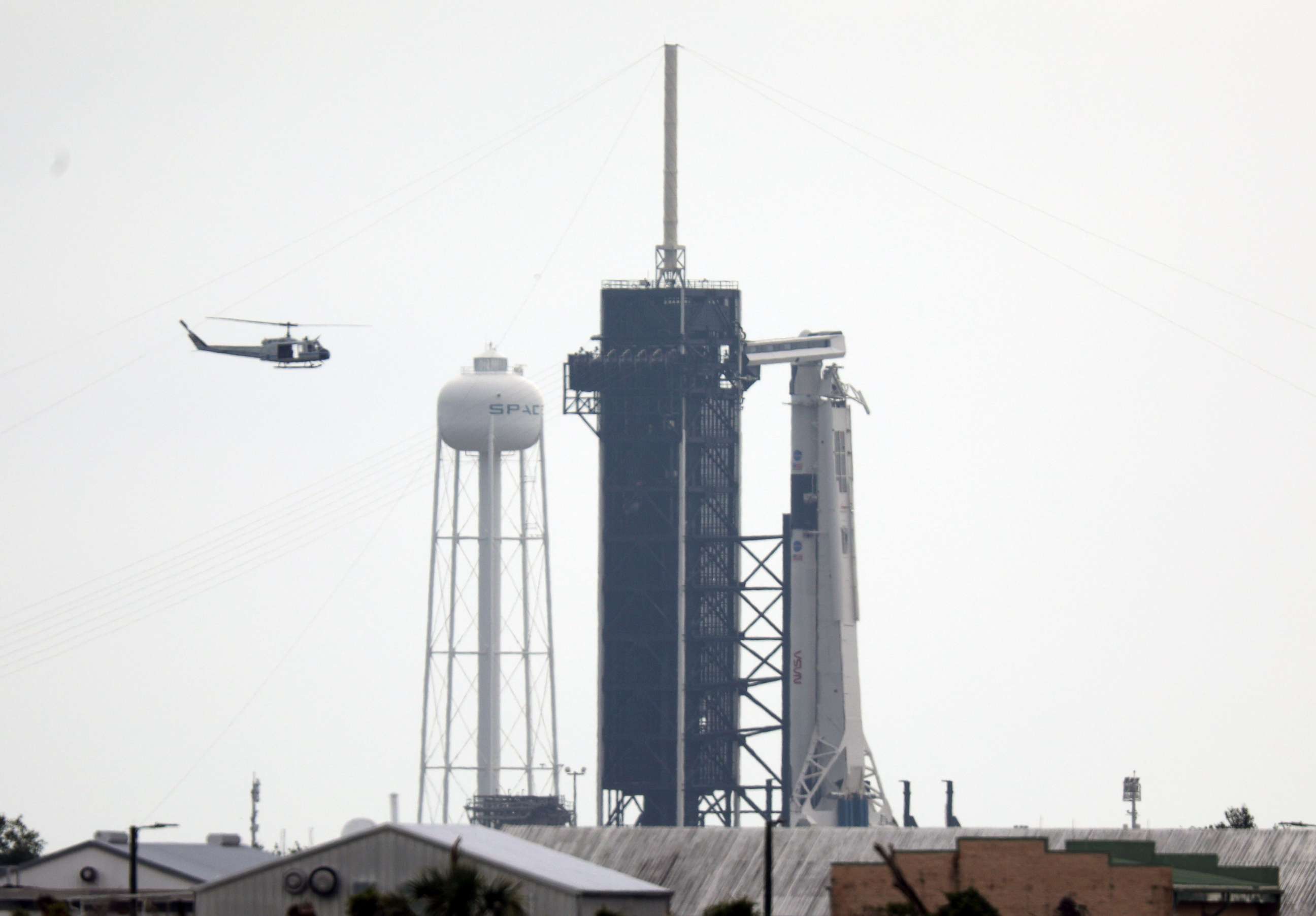 PHOTO: NASA security helicopter flies past launch complex 39A and the SpaceX Falcon 9 rocket with Crew Dragon vehicle on launch day at the Kennedy Space Center in Florida on May 26, 2020.