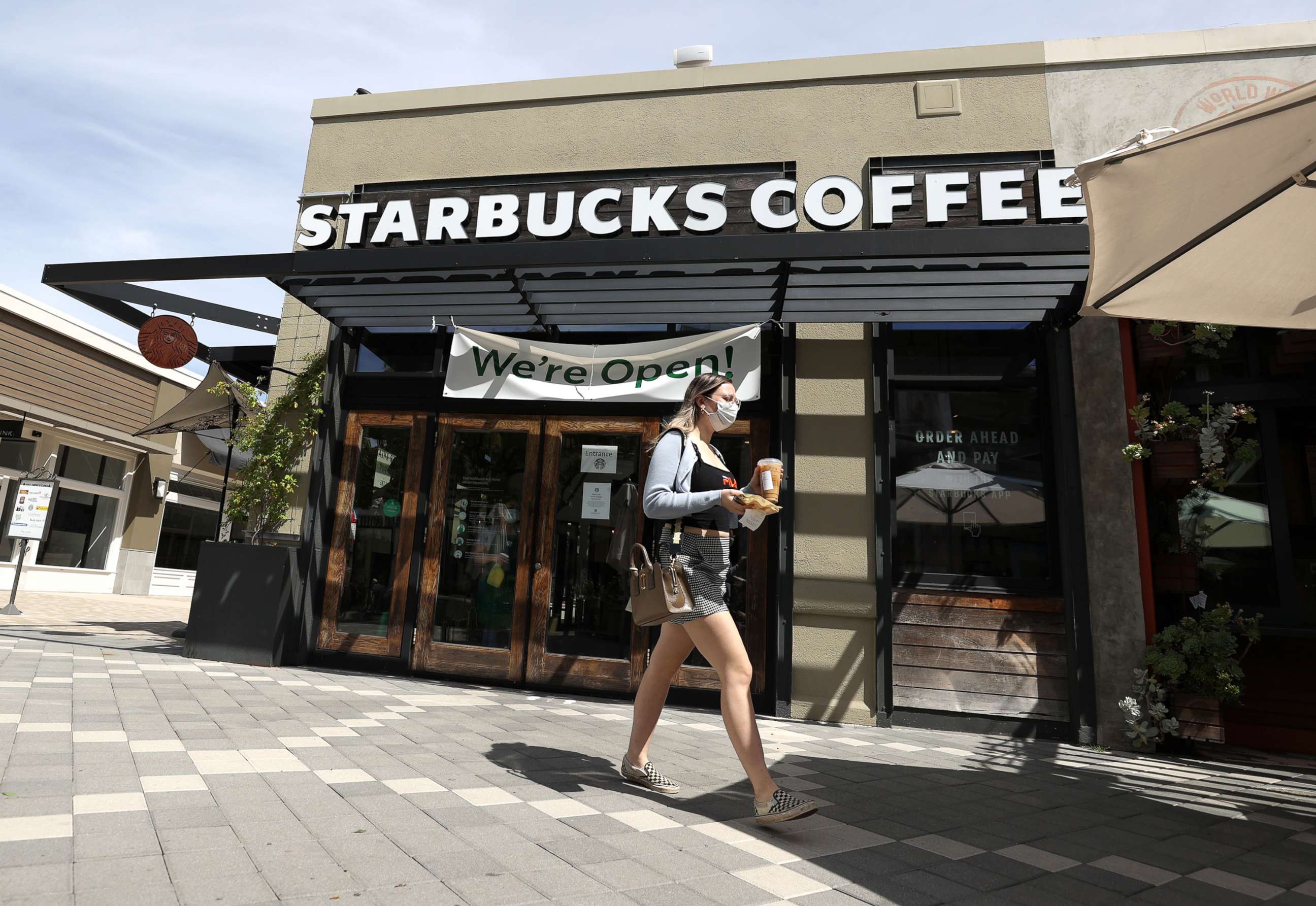 PHOTO: A customer walks by a Starbucks Coffee store, June 10, 2020, in Corte Madera, Calif.