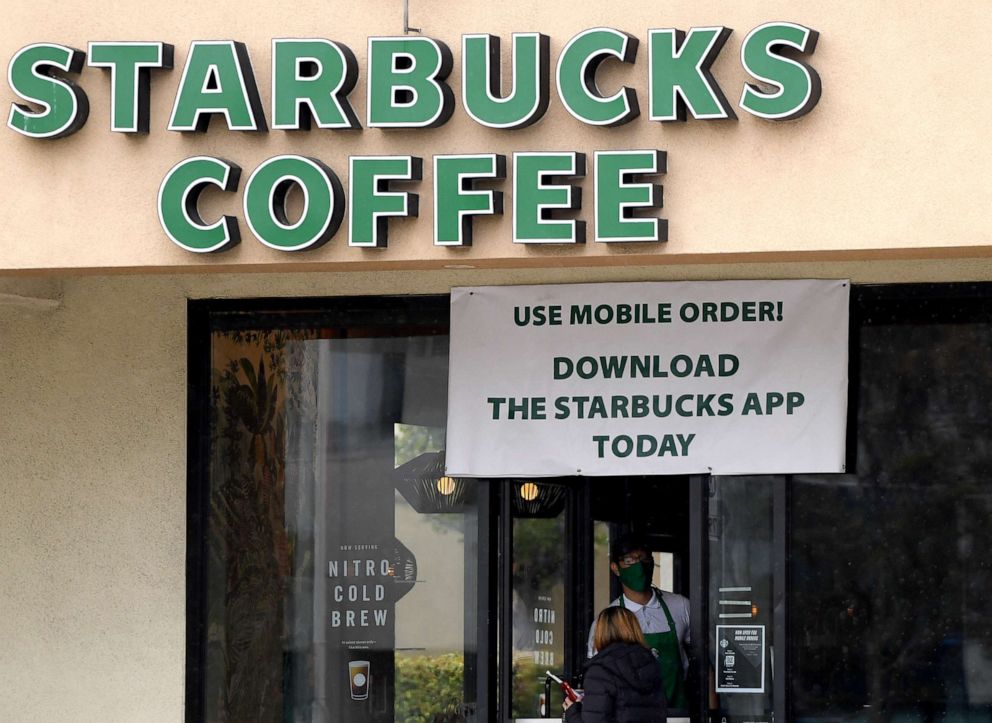 PHOTO: A Starbucks employee serves a walk-up customer amid the ongoing coronavirus pandemic, April 7, 2020, in South Pasadena, Calif.