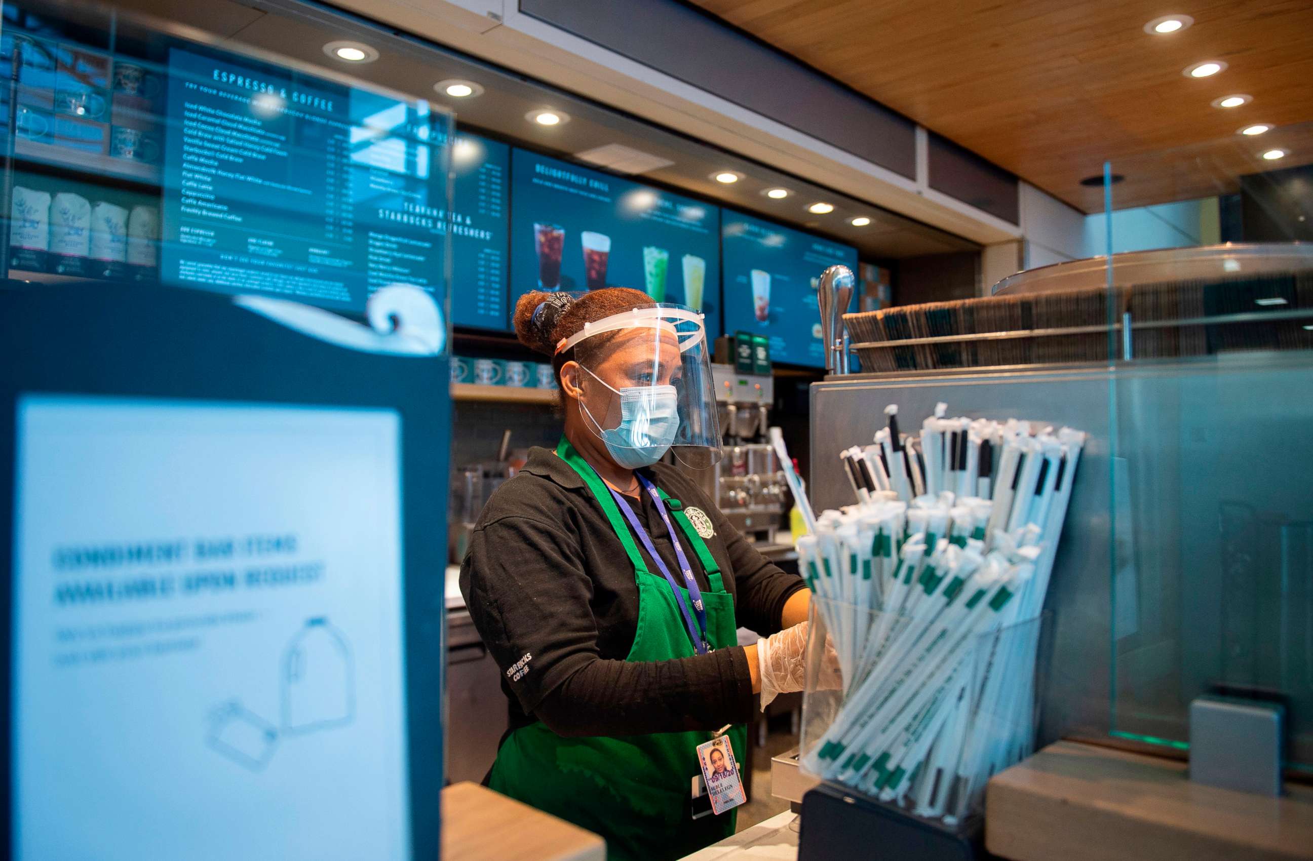 PHOTO: A Starbucks employee wears a face shield and mask as she makes a coffee in Ronald Reagan Washington National Airport in Arlington, Virginia, May 12, 2020.