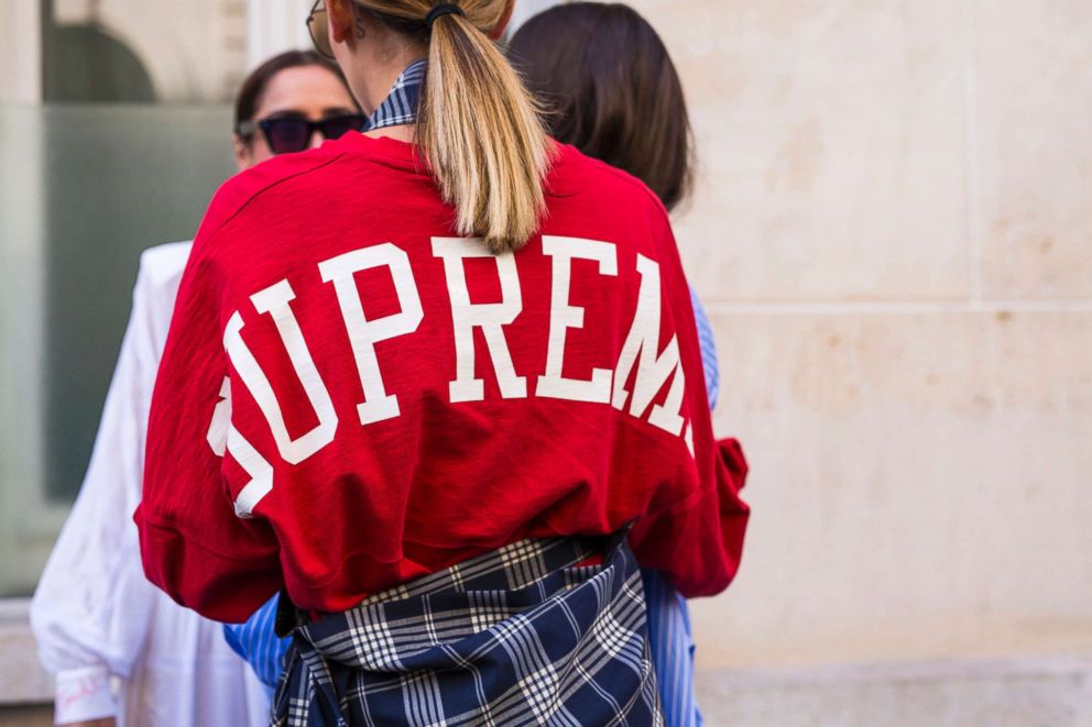 A guest wearing red Supreme belt bag is seen during the 94th Pitti