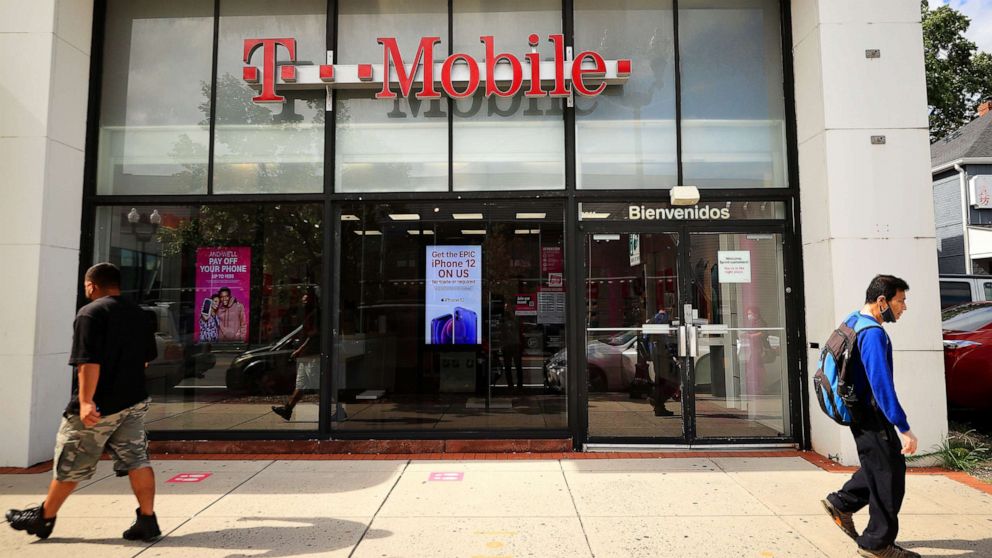 PHOTO: People walk past the front of a T-Mobile retail store on Aug. 18, 2021, in Arlington, Va.