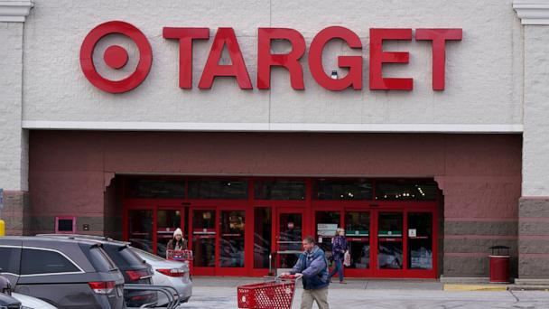 A shopper wheels a cart through the parking lot after making a purchase at the Target store, Feb. 27, 2023, in Salem, N.H.