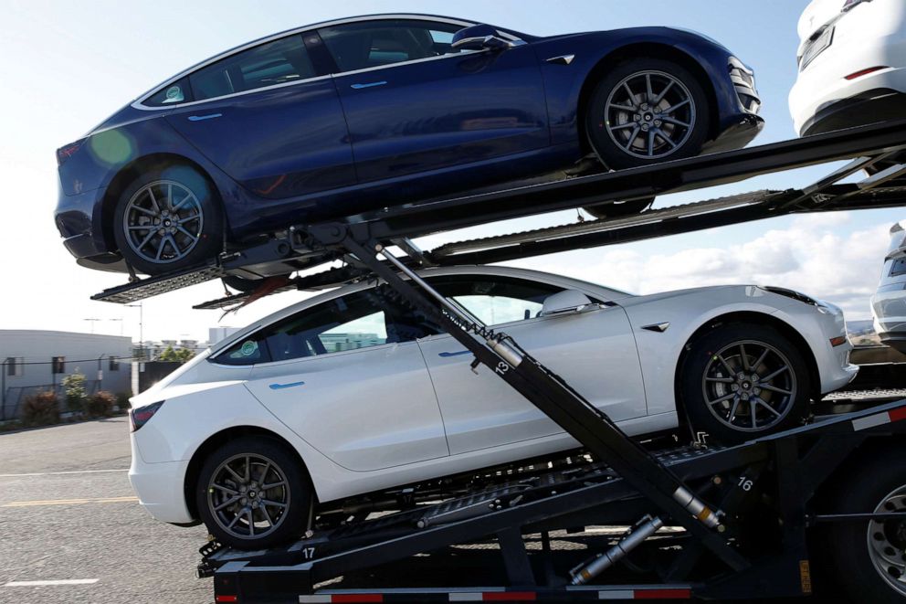 PHOTO: A car-carrying trailer transporting new Tesla Model 3 electric vehicles exits a yard at Tesla's primary vehicle factory in Fremont, Calif., May 12, 2020.