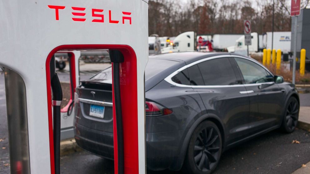 A Tesla X electric automobile recharges at a public charging station along Interstate 95 in Darien, Conn., Dec. 5, 2017.