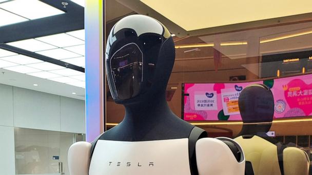 The Tesla humanoid robot Optimus Gen-2 and Tesla new energy electric vehicles on display in a Tesla store in Shanghai, China on May 15, 2025.