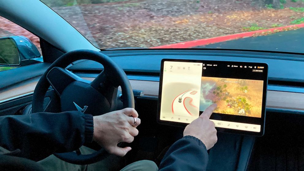PHOTO: Vince Patton, a new Tesla owner, demonstrates on Dec. 8, 2021, on a closed course in Portland, Ore., how he can play video games on the vehicle's console while driving.