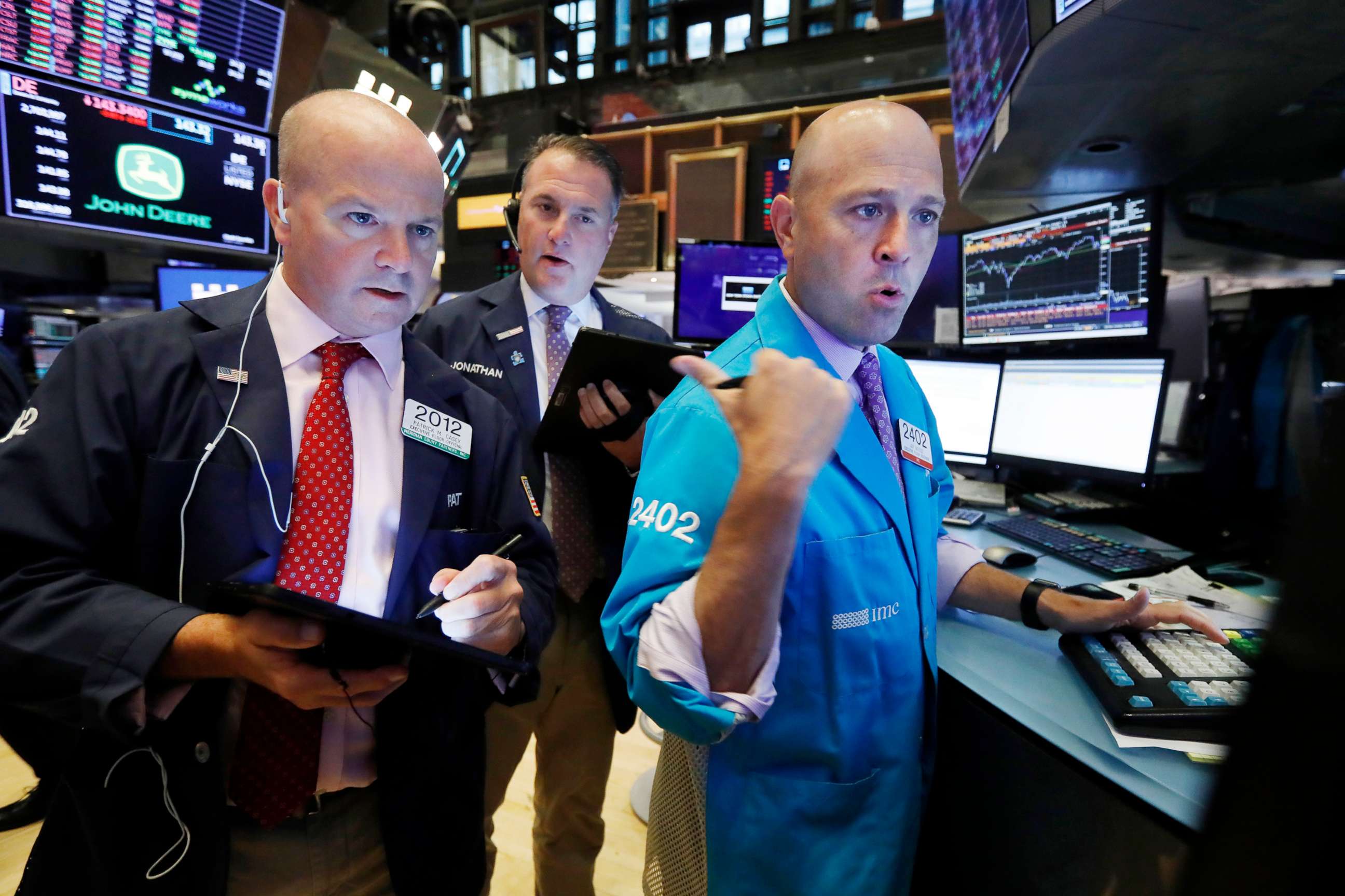 PHOTO: Traders Patrick Casey, left, and Jonathan Corpina, center, work with specialist Jay Woods on the floor of the New York Stock Exchange, Aug. 14, 2019.
