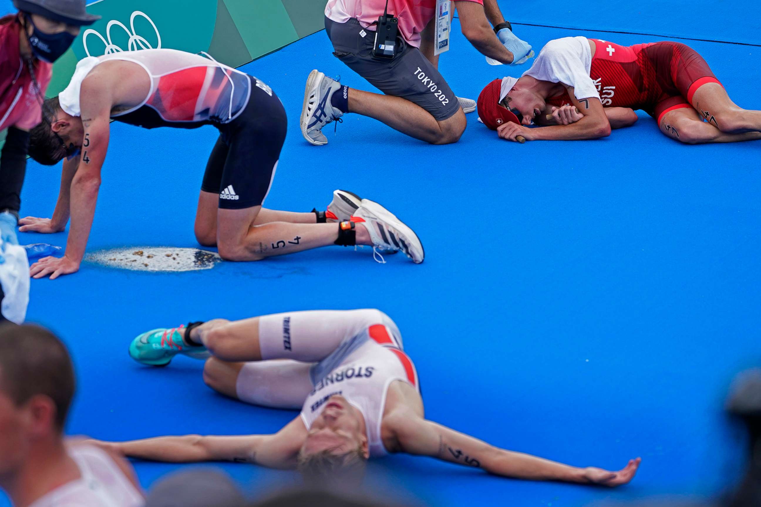 PHOTO: Max Studer, of Switzerland, is tended to after collapsing along with several other athletes, after finishing the men's individual triathlon at the 2020 Summer Olympics, July 26, 2021, in Tokyo.