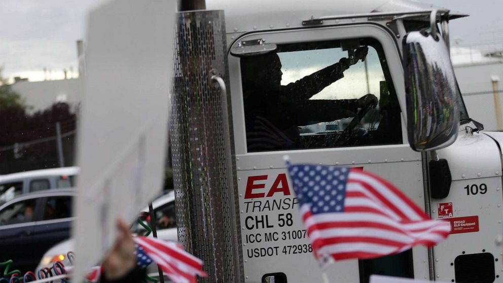 PHOTO: A truck driver honks while passing by Boeing employees and others protesting the company's coronavirus disease vaccine mandate, outside the Boeing facility in Everett, Wash., Oct. 15, 2021.