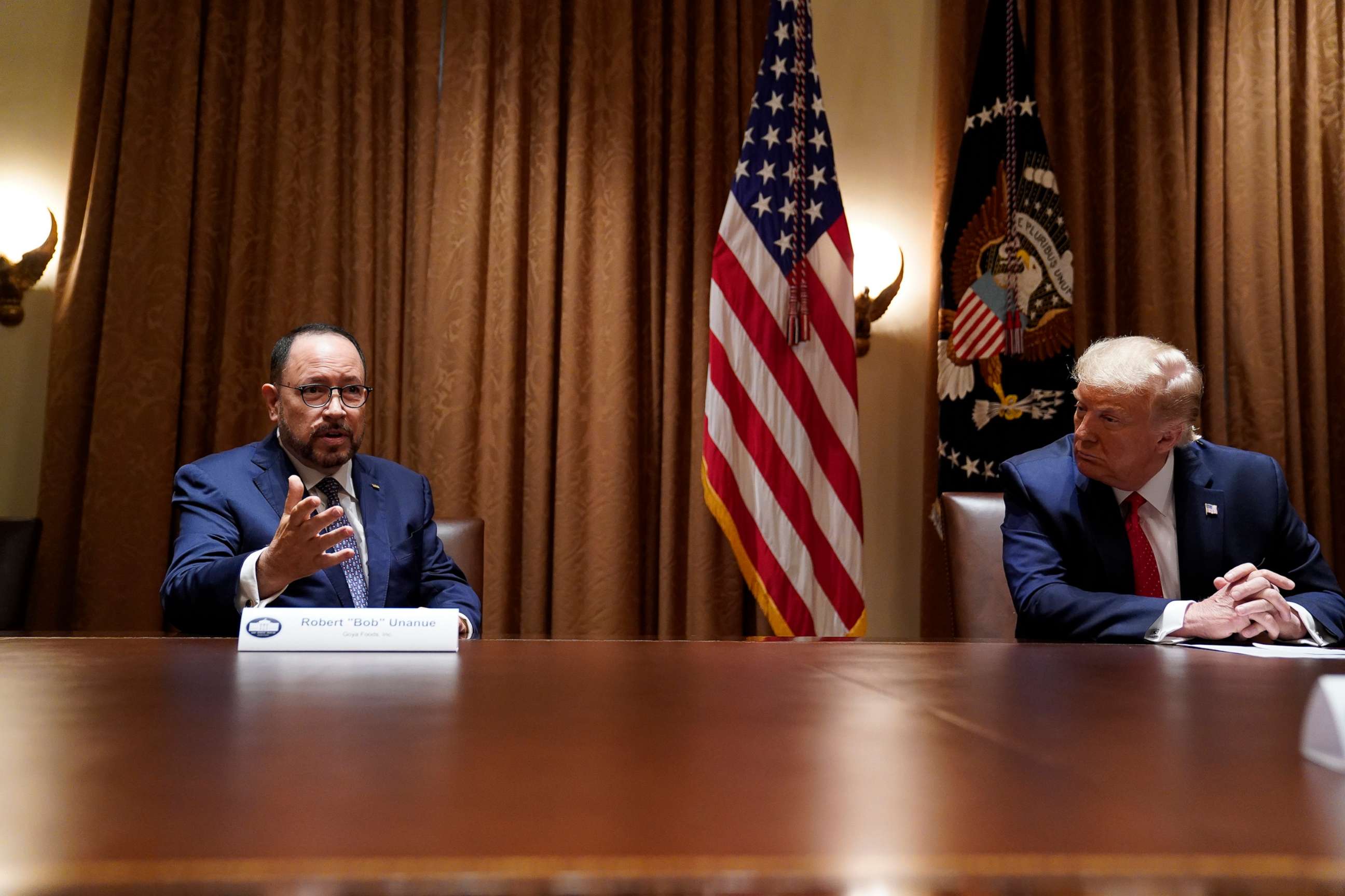 PHOTO: President Donald Trump listens as Robert Unanue, of Goya Foods, speaks during a roundtable meeting with Hispanic leaders in the Cabinet Room, July 9, 2020, in Washington.