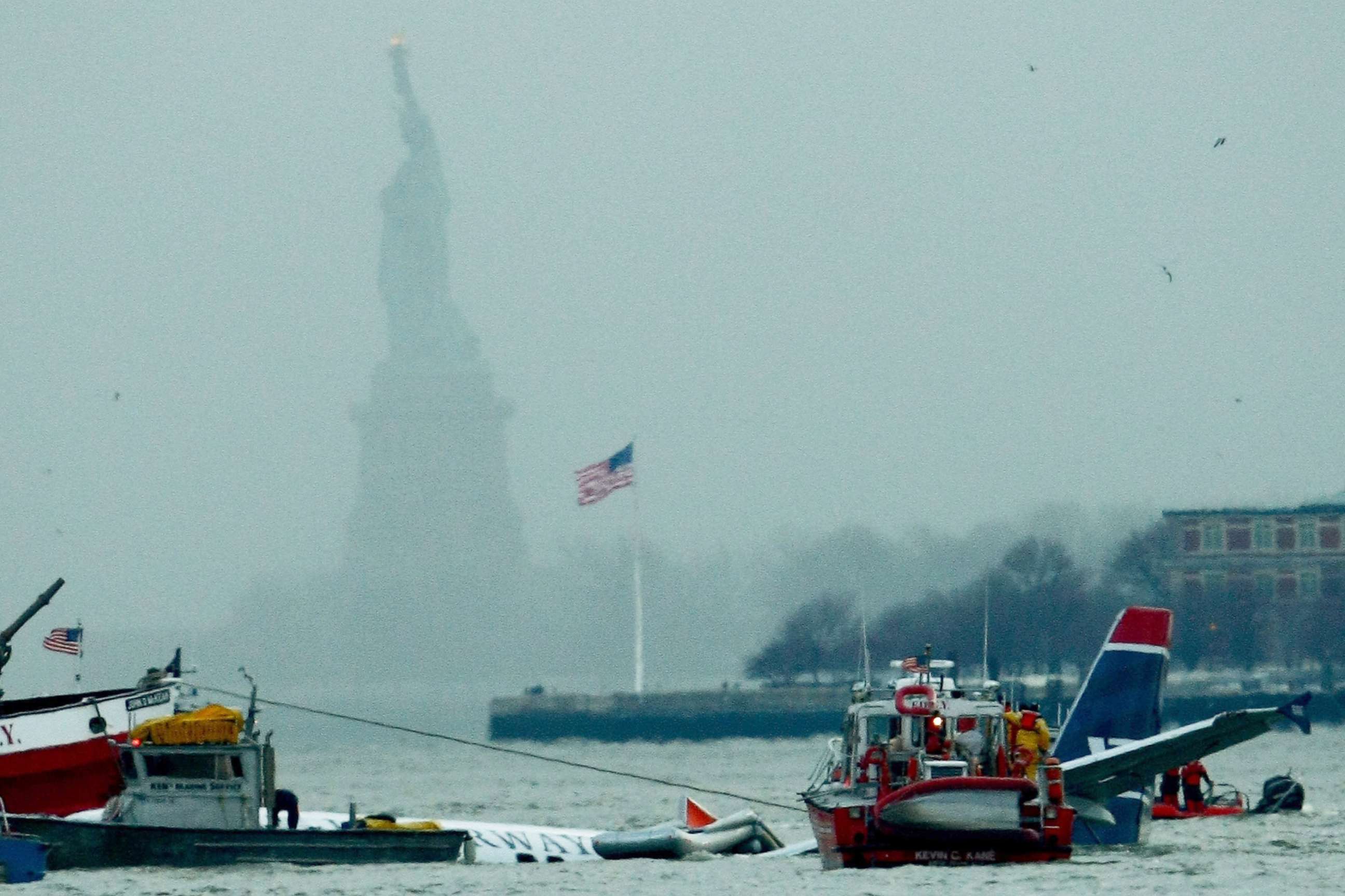 PHOTO: The statue of liberty stands in the background as rescue boats float next to a US Airways plane floating in the water after crashing into the Hudson River in New York, Jan. 15, 2009.