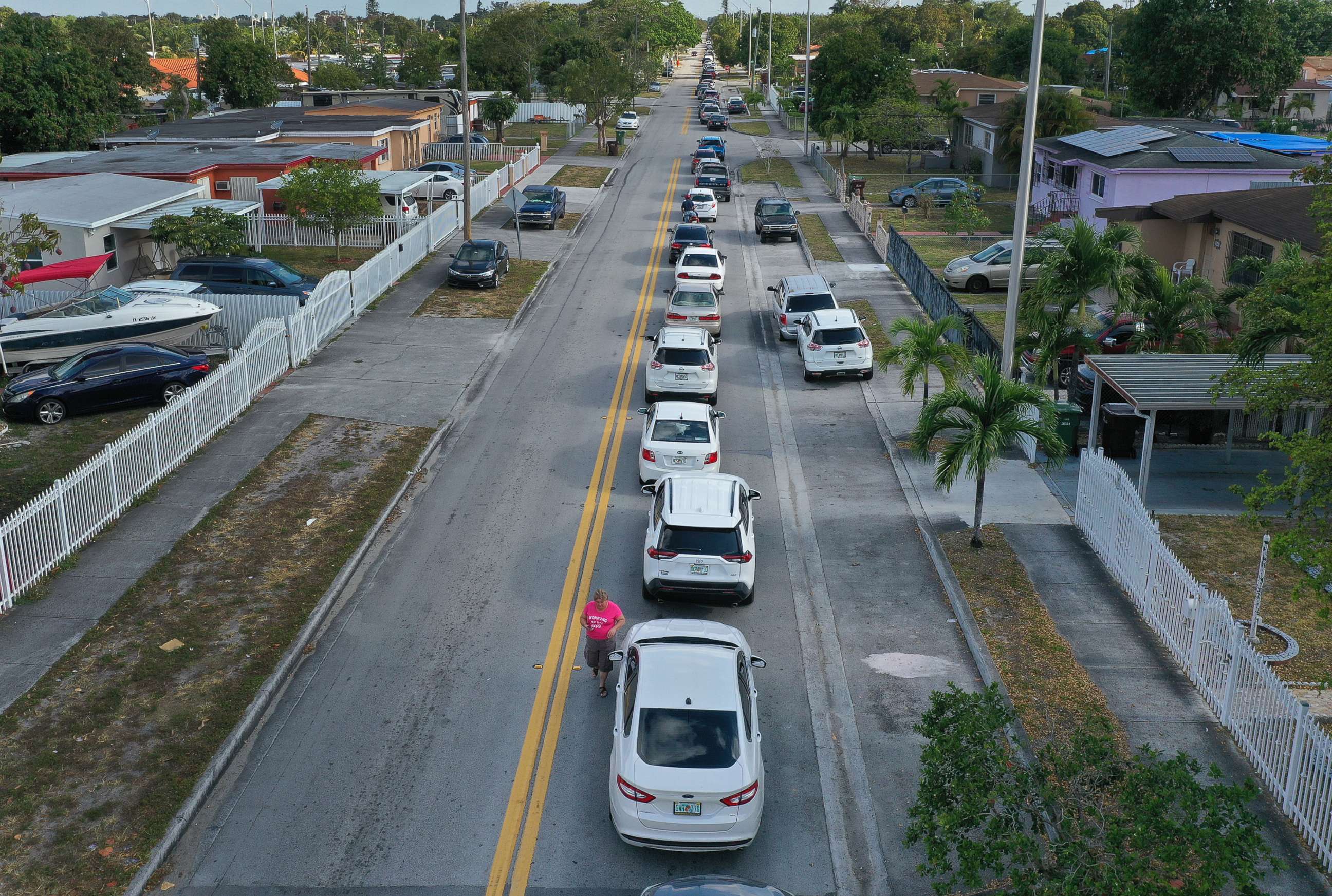 PHOTO: An aerial view from a drone shows vehicles lining up to receive unemployment applications being given out by City of Hialeah employees in front of the John F. Kennedy Library on April 8, 2020 in Hialeah, Fla.