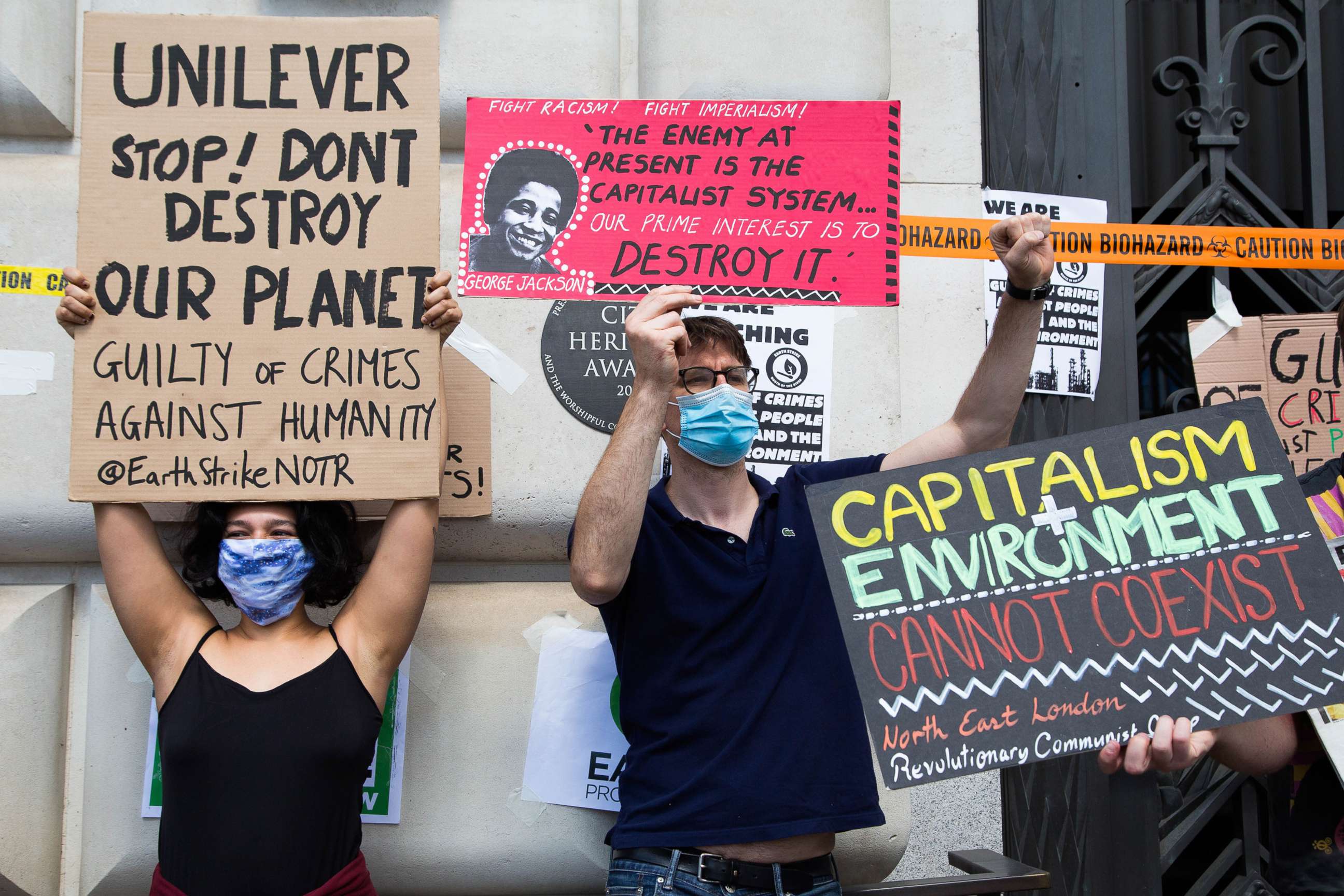 PHOTO: Protesters hold signs during the demonstration accusing Unilever of crimes against humans and the environment, July 11, 2020, outside the Unilever headquarters in London.